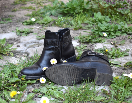 Dusty black short boots lost in grass and flowers