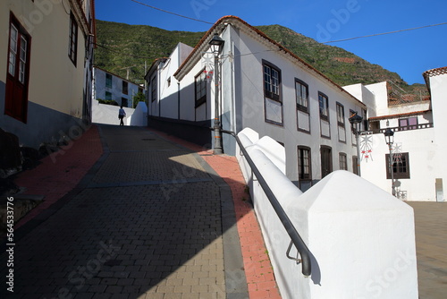 Cobbled streets and whitewashed houses in Hermigua, La Gomera, Canary Islands, Spain, with the monastic church of the Dominican monastery (El Convento de Santo Domingo) on the right side