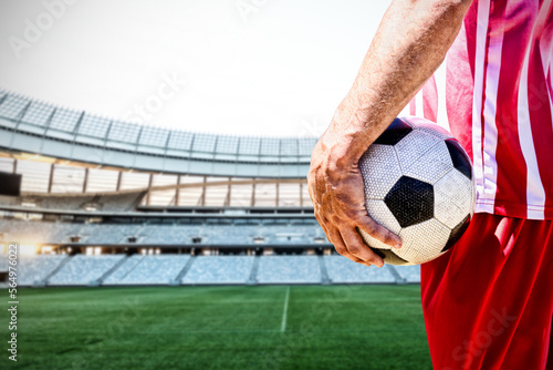 Composite image of soccer player holding ball