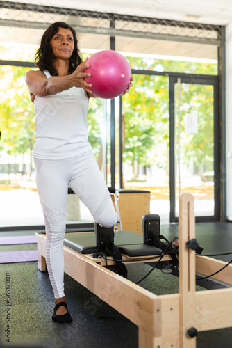 Positive woman practicing pilates with balls at group class