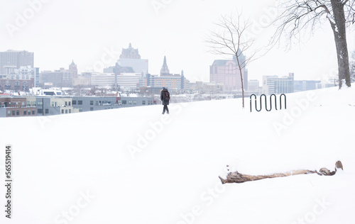 A landscape view of one person walking in a city park on a snowy day in Milwaukee, Wisconsin, USA