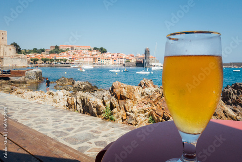 Un verre de bière face à la mer. Un verre de bière fraîche devant le village de Collioure. Les vacances à la mer. Un rafraichissement en vacances dans le sud.