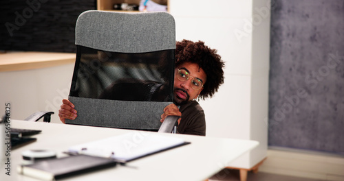 Scared Man Hiding Behind Office Desk