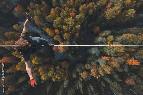 Highline over the forest. Rope walker walks on a rope at high altitude. Drone view. Slackline theme