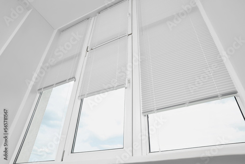 Stylish window with horizontal blinds in room, low angle view