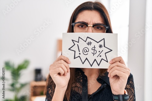 Young beautiful hispanic woman business worker holding onomatopeia banner shouting at office