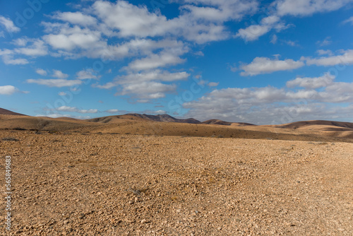 amazing desert landscape with blue sky and white clouds with mountain range in the background. Fuerteventura, Canary Islands, Spain