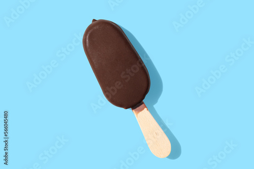 chocolate ice cream on a stick on blue pastel background