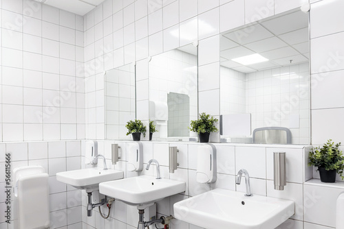 Toilet hand wash area with white colour ceramic tiles. White colour theme toilet interior. Cleanliness concept