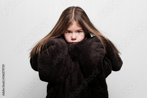 Une petite fille qui pose pour un portrait mode de vêtement trop grand pour elle