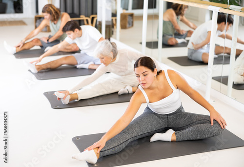 Group of different people doing exercises in fitness