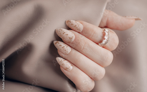 Beautiful art manicure. Holiday manicure design ideas. Female hand with beige nail design. Fashionable holiday nail design. Stylish beige nails. Close up photo.