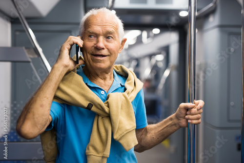 Old man with phone in subway car