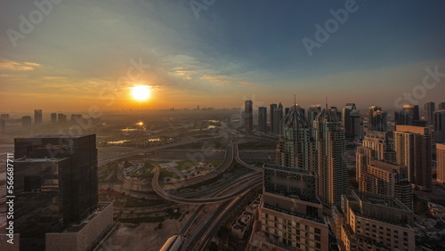 Sunrise over Dubai marina and JLT skyscrapers along Sheikh Zayed Road aerial .