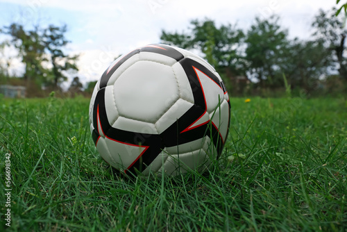 New soccer ball on fresh green grass outdoors
