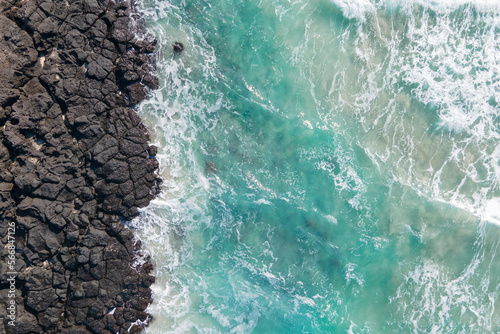 Sea and volcanic rocks close-up aerial view, natural background.