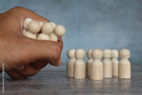 Hand grab wooden dolls. Mass layoffs, downsizing concept.