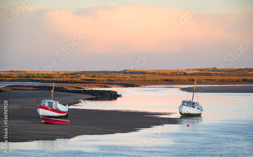 Fishing boats at low tide on the sea creek at Burnham Overy Staithe, Norfolk at sunrise