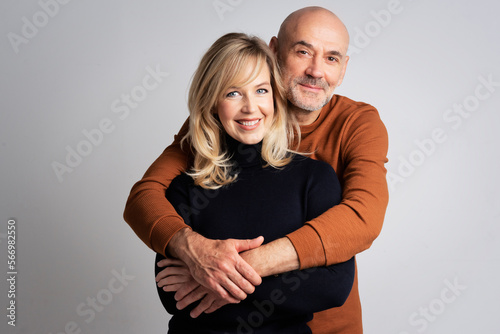 Happy couple standing at isolated background embracing each other