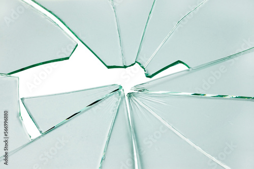 The hole in the broken and cracked glass on white background, closeup