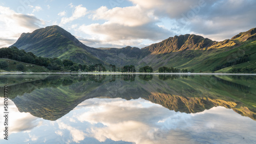 Buttermere in the Lake District with trees and mountains in reflection, beautifully calm water with long exposure 