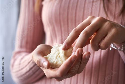 Woman holding a piece of raw shea butter or karite