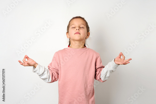 Cute girl meditating with closed eyes, white background