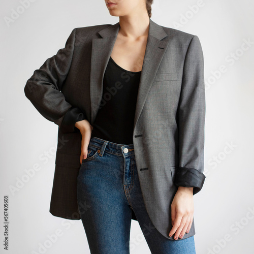 Woman wearing oversized blazer and blue jeans isolated on white background