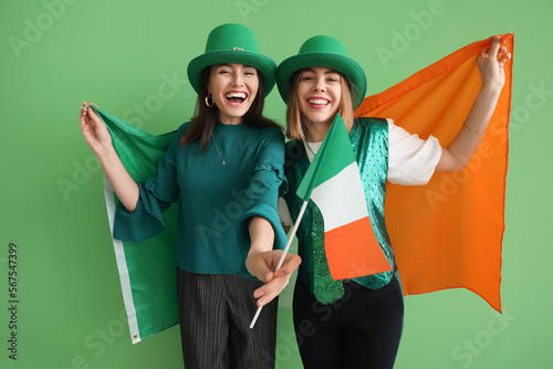Young women with flags of Ireland on green background. St. Patrick's Day celebration