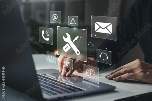 Businessman using laptop with helpdesk icon on screen, Hotline assistance service available by phone, chat, email, Technical support customer service concept.