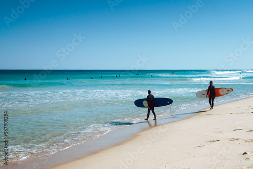 Two surfers walking into the ocean at Scarborough Beach in Perth, Western Australia