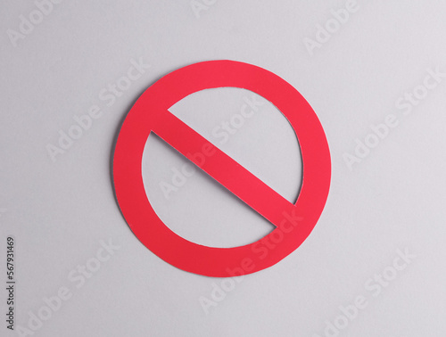 Red prohibition sign cut out of paper on a gray background