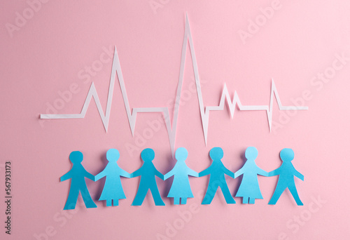 People Chain with a cardiological heart rhythm cut out of paper on pink background. Nation health