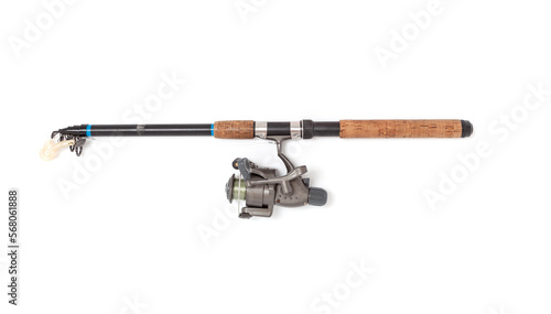 Assembled telescopic spinning rod with reel lies on white background..