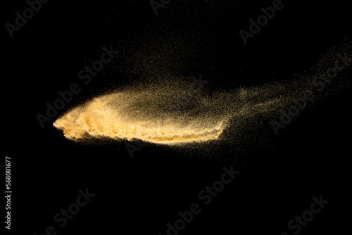 Brown colored sand splash.Dry river sand explosion isolated on black background.