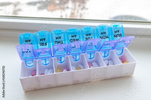 A full pill box or vitamin organizer with the days of the week separated individually by am and pm to help remind when medication should be taken.