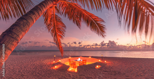 Amazing view under sunset light with dining table chairs on soft sand. Romantic tropical getaway for two, love couple concept. Candles, food and romance. Luxury destination dining, honeymoon template
