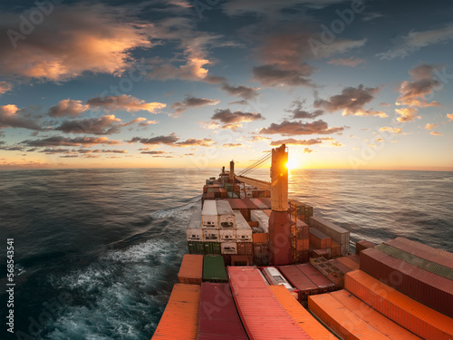 Large container vessel with cranes at the open sea or ocean.