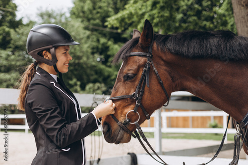 Equestrian sport - a young girl is standing near horse