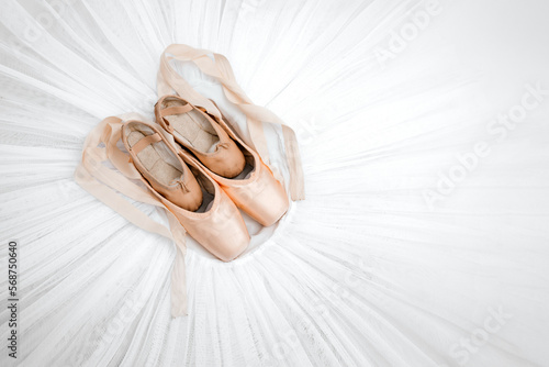Professional ballet shoes with ribbons on white tutu. Professional ballet outfit. Large and small pointe shoes