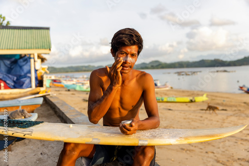 Indonesia, Lombok, Male surfer applying sun lotion on face 