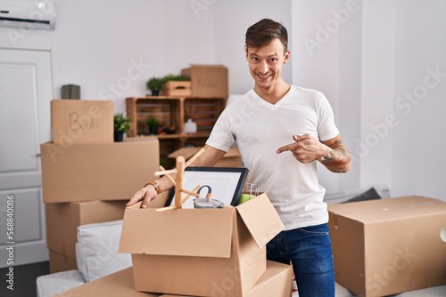 Caucasian man holding screwdriver at new home smiling happy pointing with hand and finger