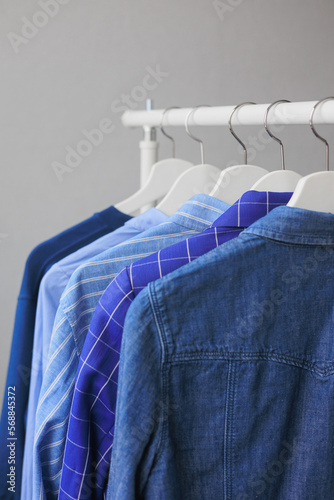 hangers with clothes, wardrobe shirt jacket blue. storing clothes or shopping. stylist selection of look for work and walking. fashion and casual wear