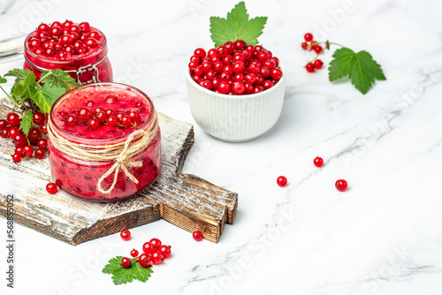 Preserved berry Homemade jam. Glass jar with red currant jam on a light background. Long banner format. top view