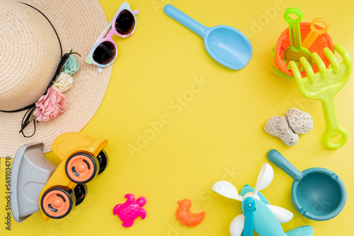 Top view of beach summer accessories for children. Fashion sunglasses, straw hat and beach toys. Vacation, holiday, summer, trip and travel concept. Flat lay. 