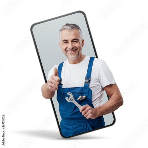 Cheerful repairman and plumber giving a thumbs up in a smartphone videocall and smiling, online service concept