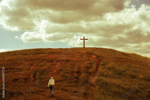 Person walking towards a cross on the hill