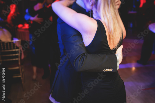 Couples dancing traditional latin argentinian dance milonga in the ballroom on a festival, tango studio, salsa, bachata and kizomba lesson in the red and purple lights, rehearsal in the dance class