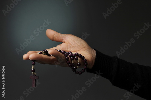 man praying to god with cross and hands together with black background with people stock photo 