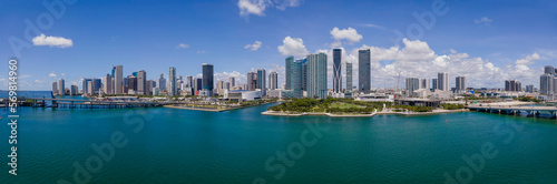 Panorama of city skyline and Intracoastal Waterway in Miami Beach Florida. Beaautiful buildings and skyscrapers surrounded by inland water channel against blue sky and clouds.